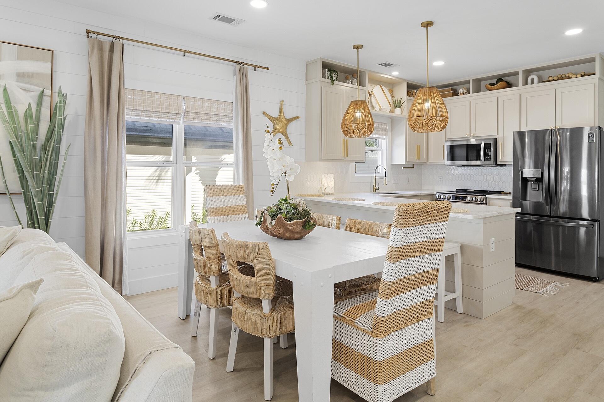 53 Gulfside Way Miramar Beach, FL 32550 - Photo 6 of 34 a kitchen with stainless steel appliances granite countertop a table chairs refrigerator and a sink