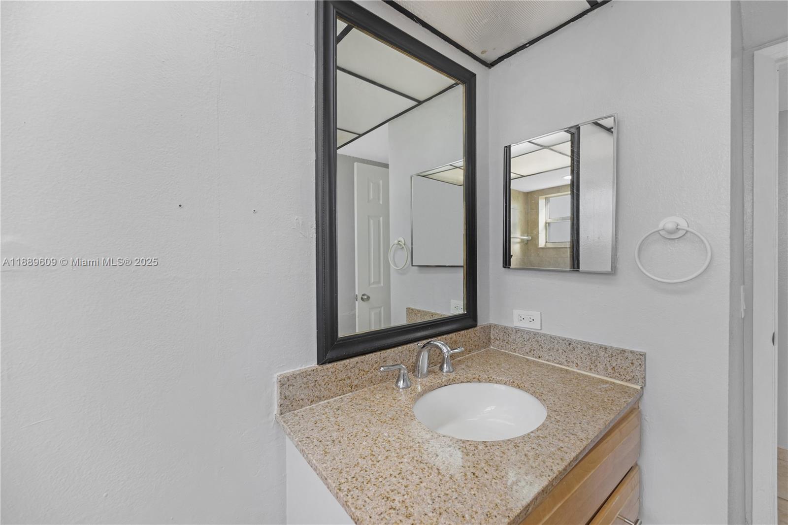 1750 West 46th Street, Unit 544 Hialeah, FL 33012 - Photo 18 of 46 a bathroom with a granite countertop sink and a mirror