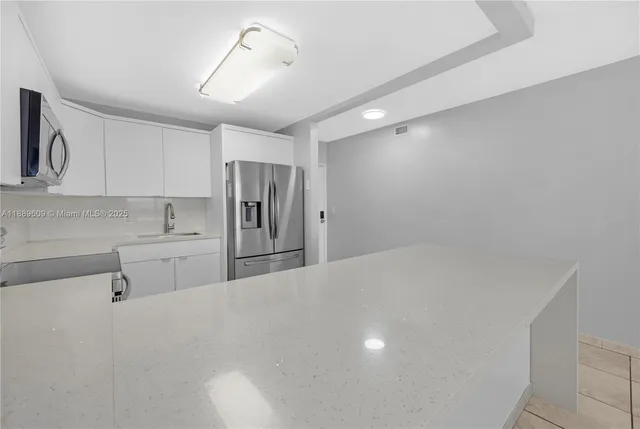 a kitchen with stainless steel appliances a refrigerator and cabinets