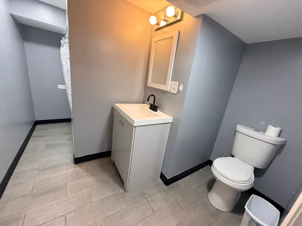 a white toilet sitting next to a white sink and vanity