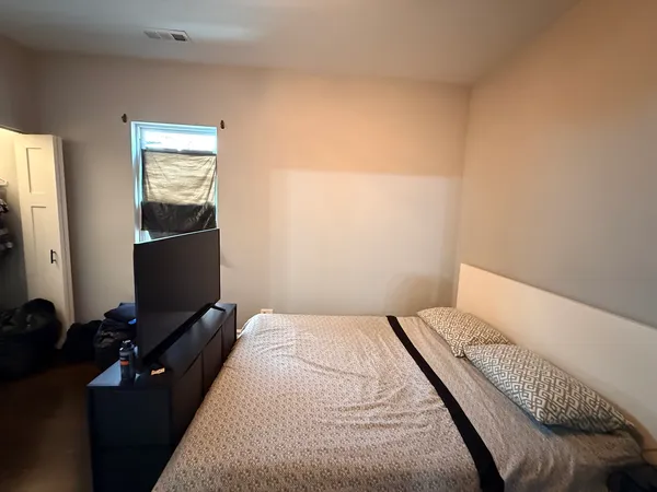 a bedroom with a bed and wooden floor