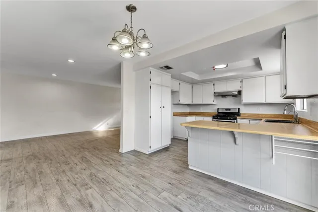 a kitchen with stainless steel appliances granite countertop a sink a stove a refrigerator and cabinets