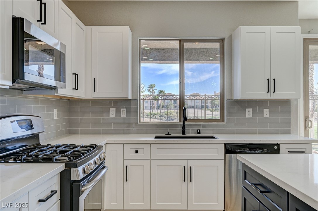 153 Tall Ruff Drive Las Vegas, NV 89148 - Photo 18 of 59 Kitchen with white cabinetry, a sink, and stainles