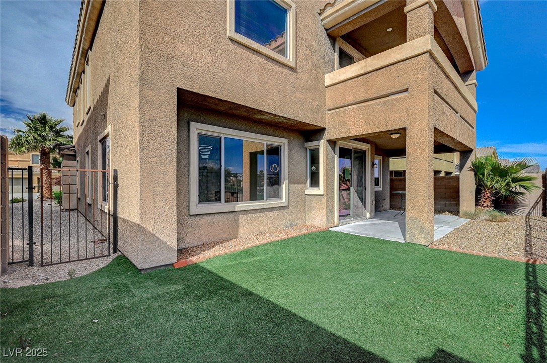 153 Tall Ruff Drive Las Vegas, NV 89148 - Photo 32 of 59 Back of house with a gate, stucco siding, fence, a