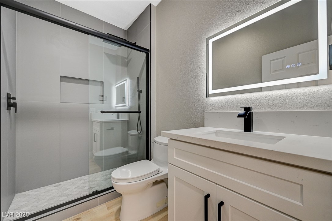 153 Tall Ruff Drive Las Vegas, NV 89148 - Photo 54 of 59 Bathroom with toilet, vanity, a shower stall, wood