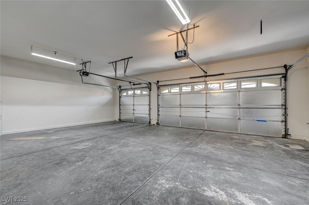 153 Tall Ruff Drive Las Vegas, NV 89148 - Photo 58 of 59 Garage featuring a garage door opener and baseboar