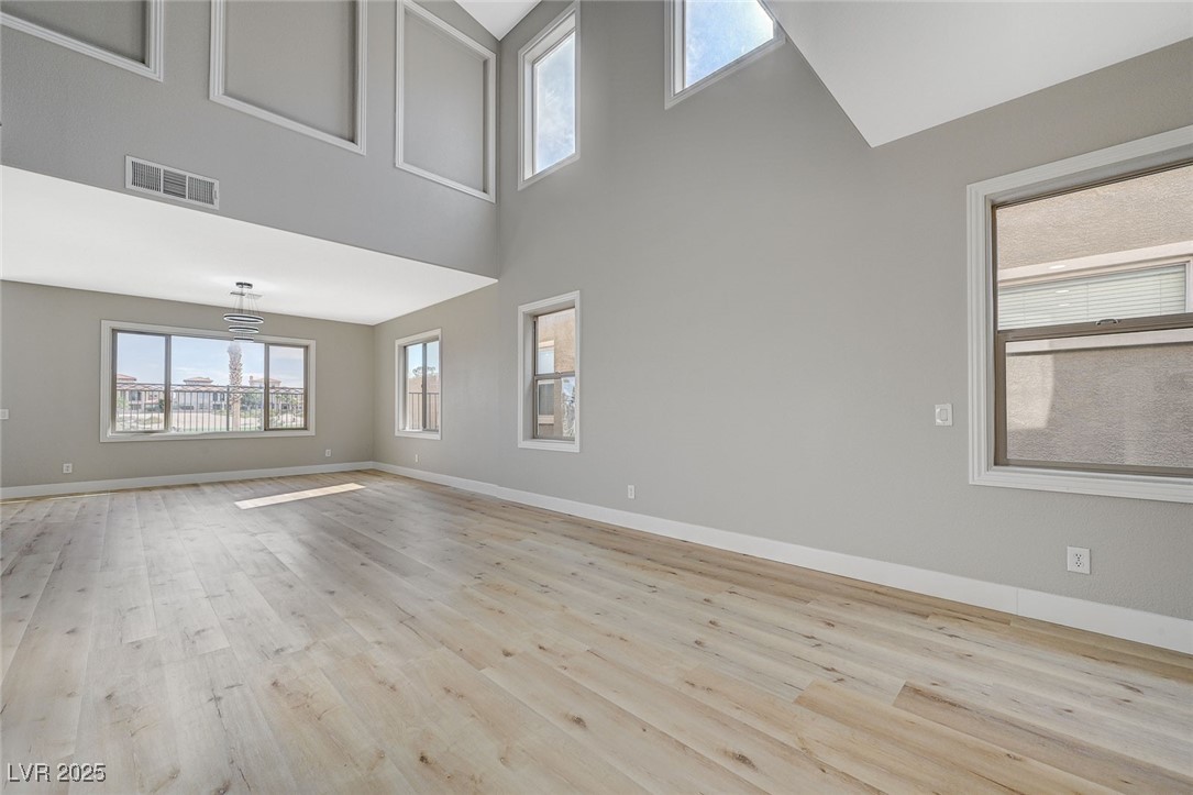 153 Tall Ruff Drive Las Vegas, NV 89148 - Photo 10 of 59 Empty room with wood finished floors, a towering c