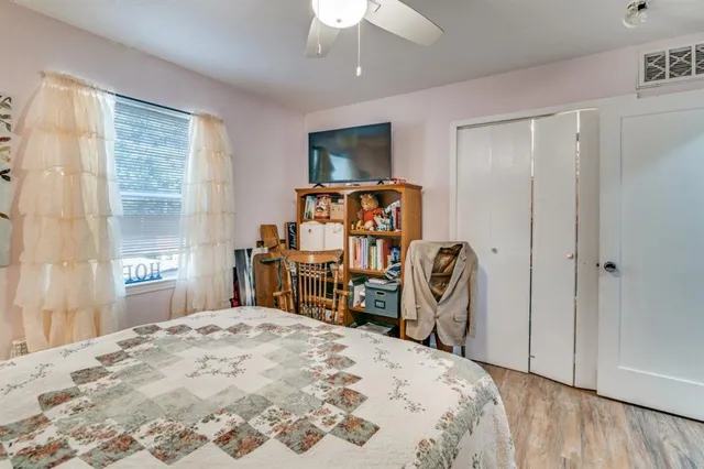 a bedroom with a bed a chandelier and dresser