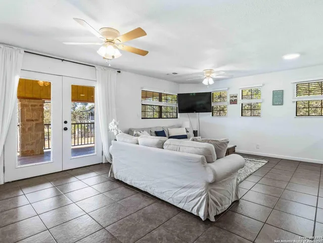 a living room with furniture a ceiling fan and a window
