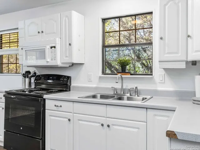 a kitchen with cabinets appliances and a window