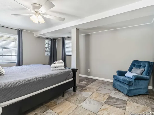 a spacious bedroom with a bed and ceiling fan