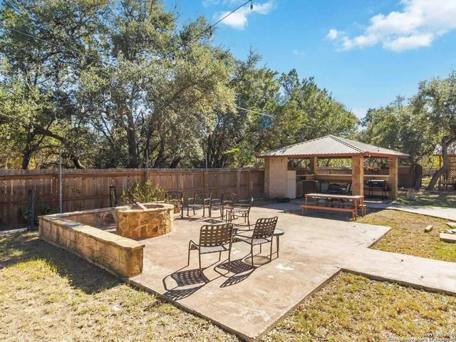 a view of a patio with a table and chairs under an umbrella