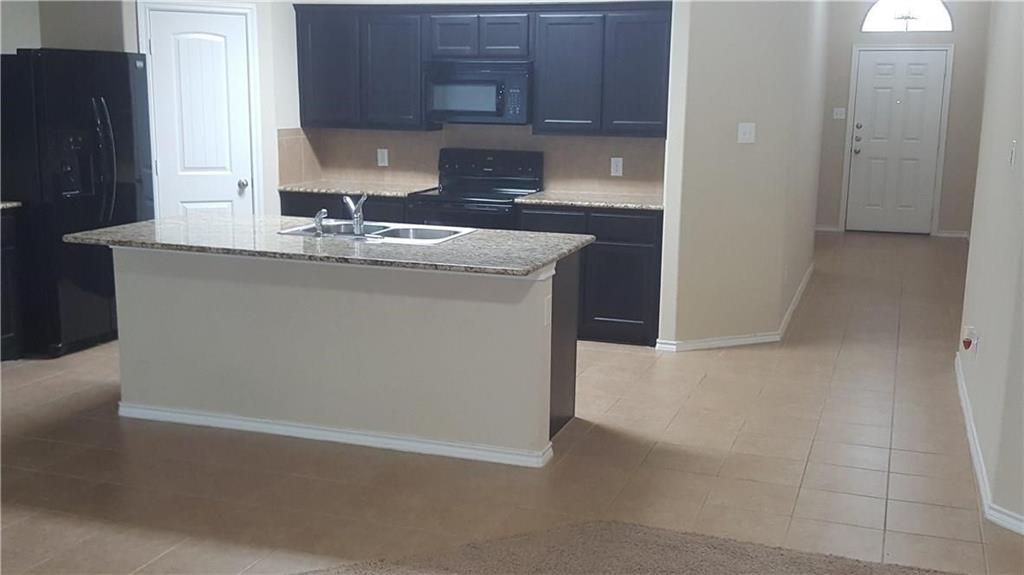 8217 Spotted Doe Drive Fort Worth, TX 76179 - Photo 7 of 22 a kitchen with granite countertop a sink and a stove with wooden floor