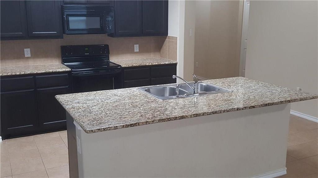 8217 Spotted Doe Drive Fort Worth, TX 76179 - Photo 8 of 22 a kitchen with granite countertop a sink a stove and a microwave
