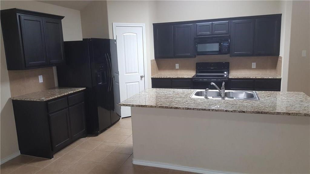 8217 Spotted Doe Drive Fort Worth, TX 76179 - Photo 9 of 22 a kitchen with granite countertop a refrigerator and a sink