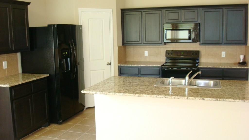 8217 Spotted Doe Drive Fort Worth, TX 76179 - Photo 10 of 22 a kitchen with granite countertop a refrigerator and a stove top oven