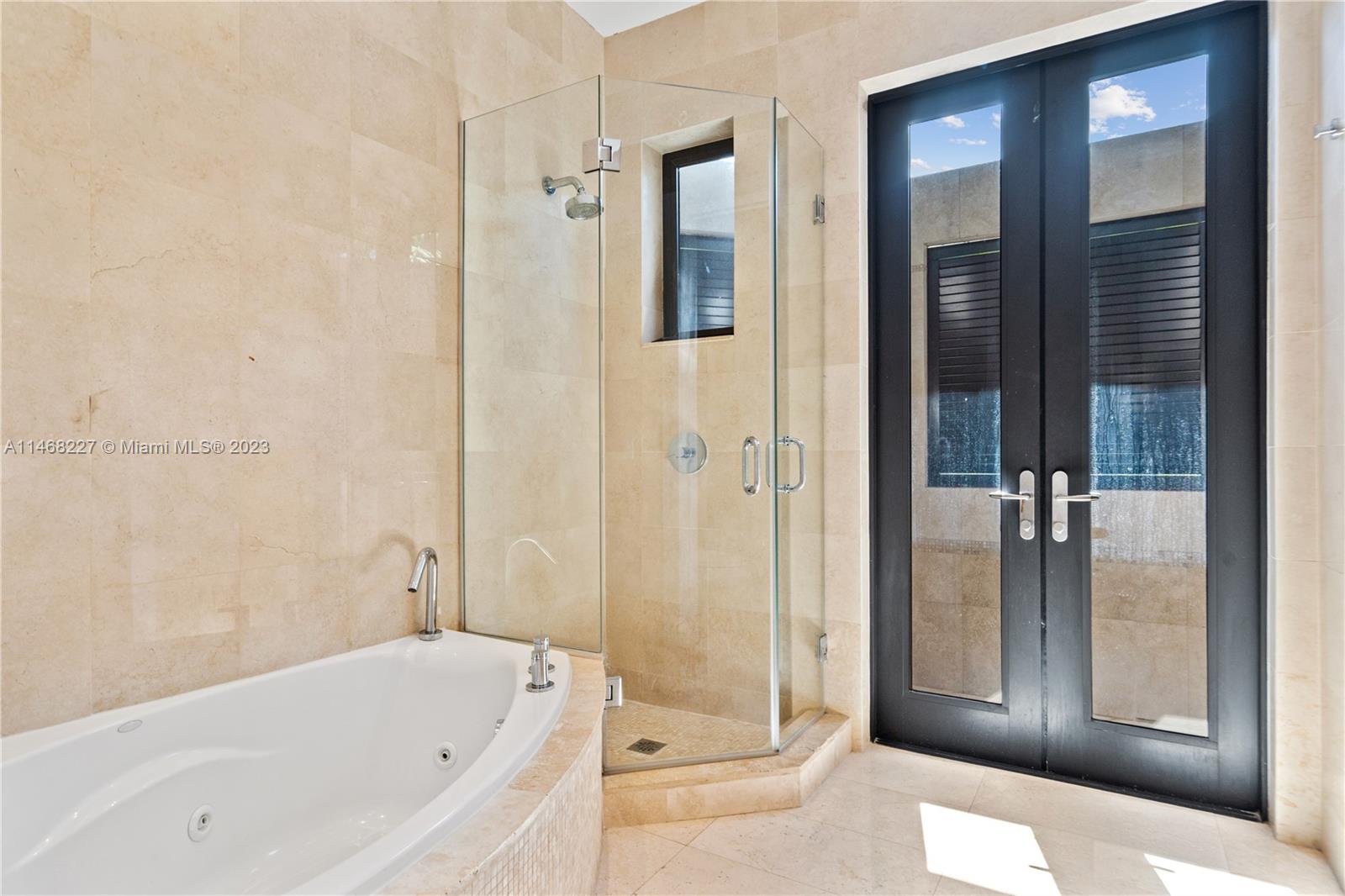 512 Fernwood Road, Unit 2 Key Biscayne, FL 33149 - Photo 8 of 23 a bathroom with a bathtub and a shower
