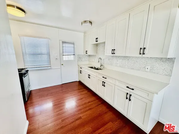 a kitchen with cabinets wooden floor and a sink