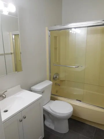a bathroom with a toilet sink vanity and shower