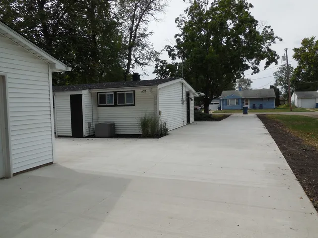 a view of a house with backyard and trees