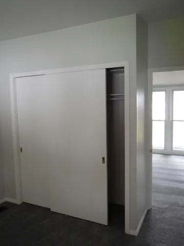 an empty room with wooden floor and closet