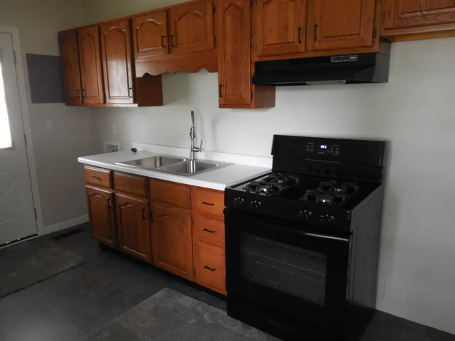 a kitchen with stainless steel appliances granite countertop a stove a sink and a microwave