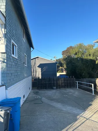 a view of backyard with barbeque grill and wooden fence