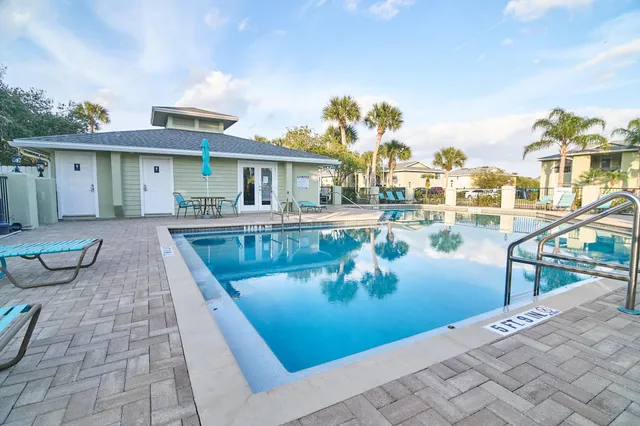 a view of a house with pool and chairs