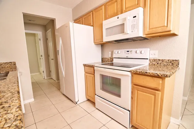 a kitchen with white cabinets and white appliances