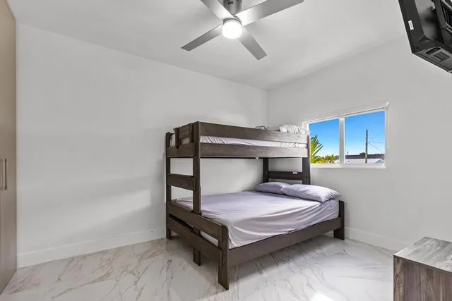 a bedroom with a bed and ceiling fan