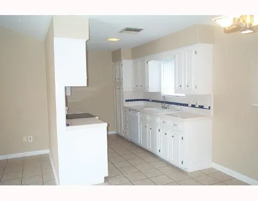 a kitchen with granite countertop white cabinets and a sink