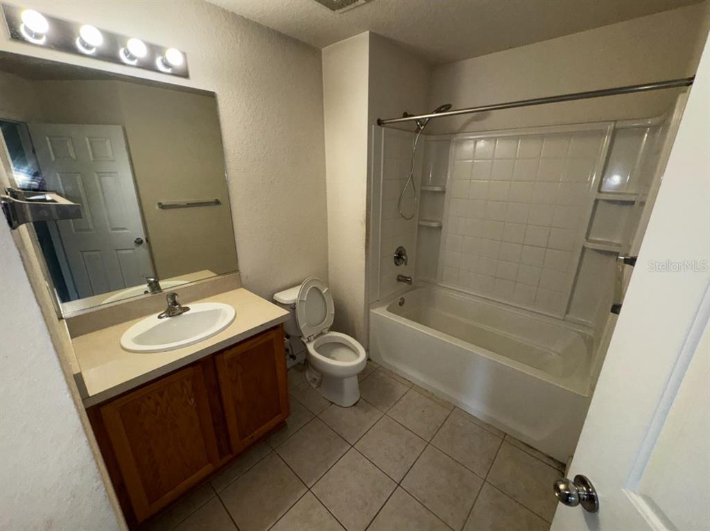 4202 Southwest 55th Circle, Unit C Ocala, FL 34474 - Photo 12 of 15 a bathroom with a sink a toilet and shower