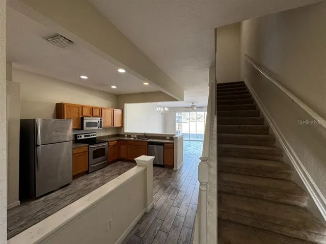 a kitchen with a refrigerator and a stove top oven