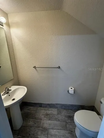 a bathroom with a toilet a sink and mirror