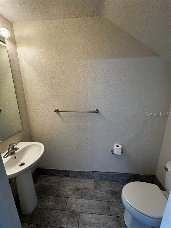 4202 Southwest 55th Circle, Unit C Ocala, FL 34474 - Photo 5 of 15 a bathroom with a toilet a sink and mirror
