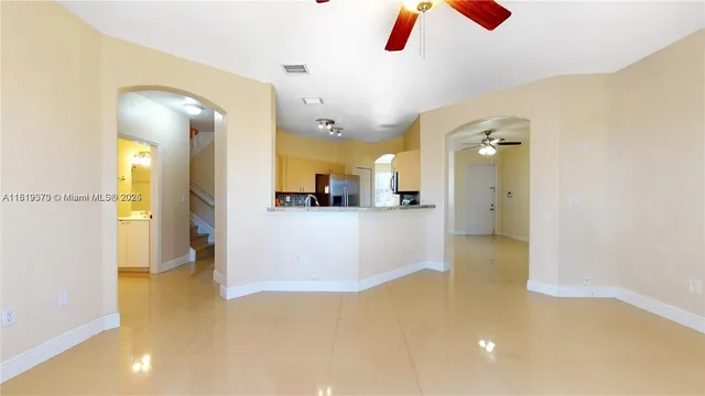 an empty room with windows and ceiling fan