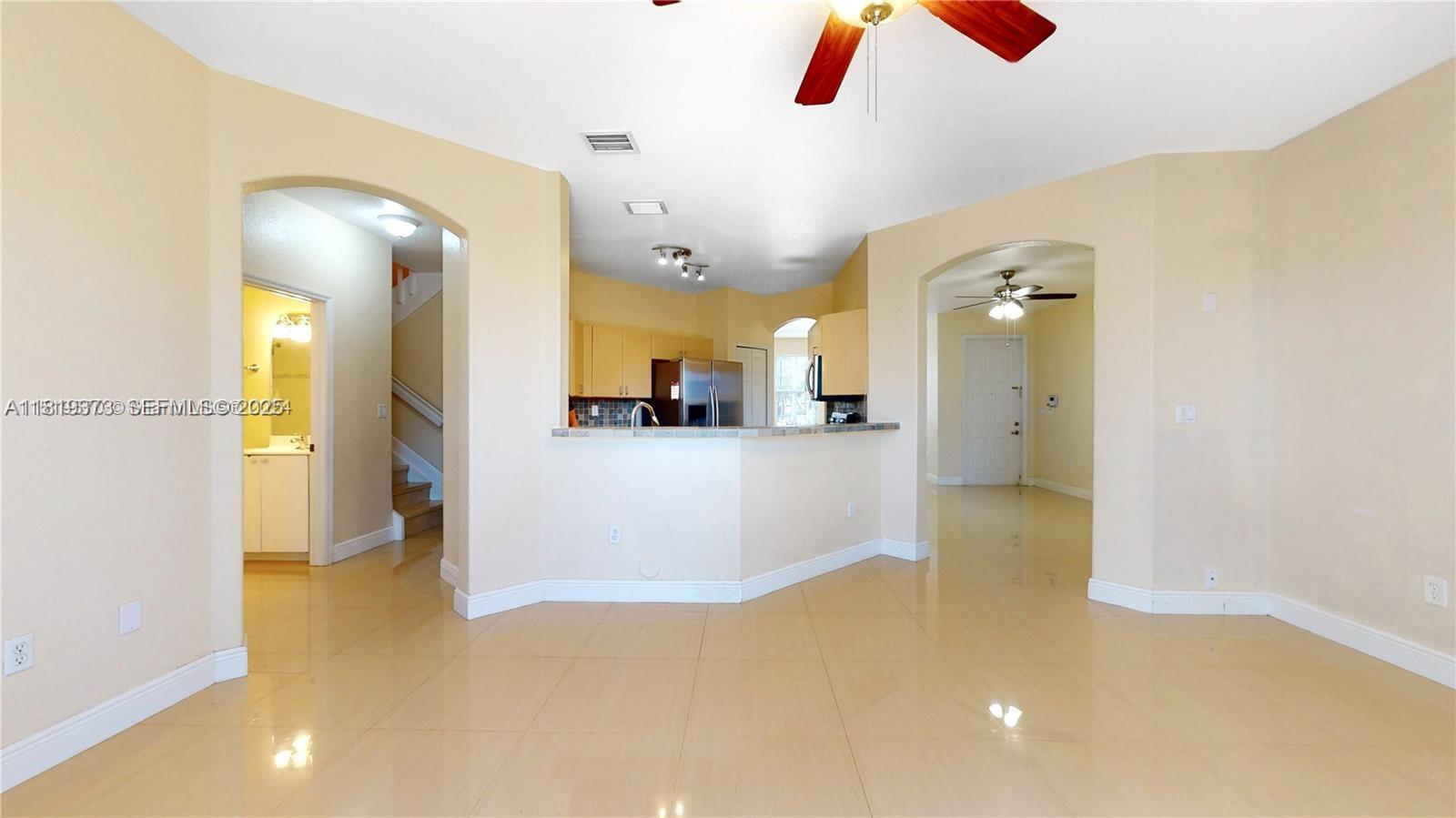 12281 Southwest 121st Terrace Miami, FL 33186 - Photo 13 of 58 a view of a living room with a refrigerator and chandelier