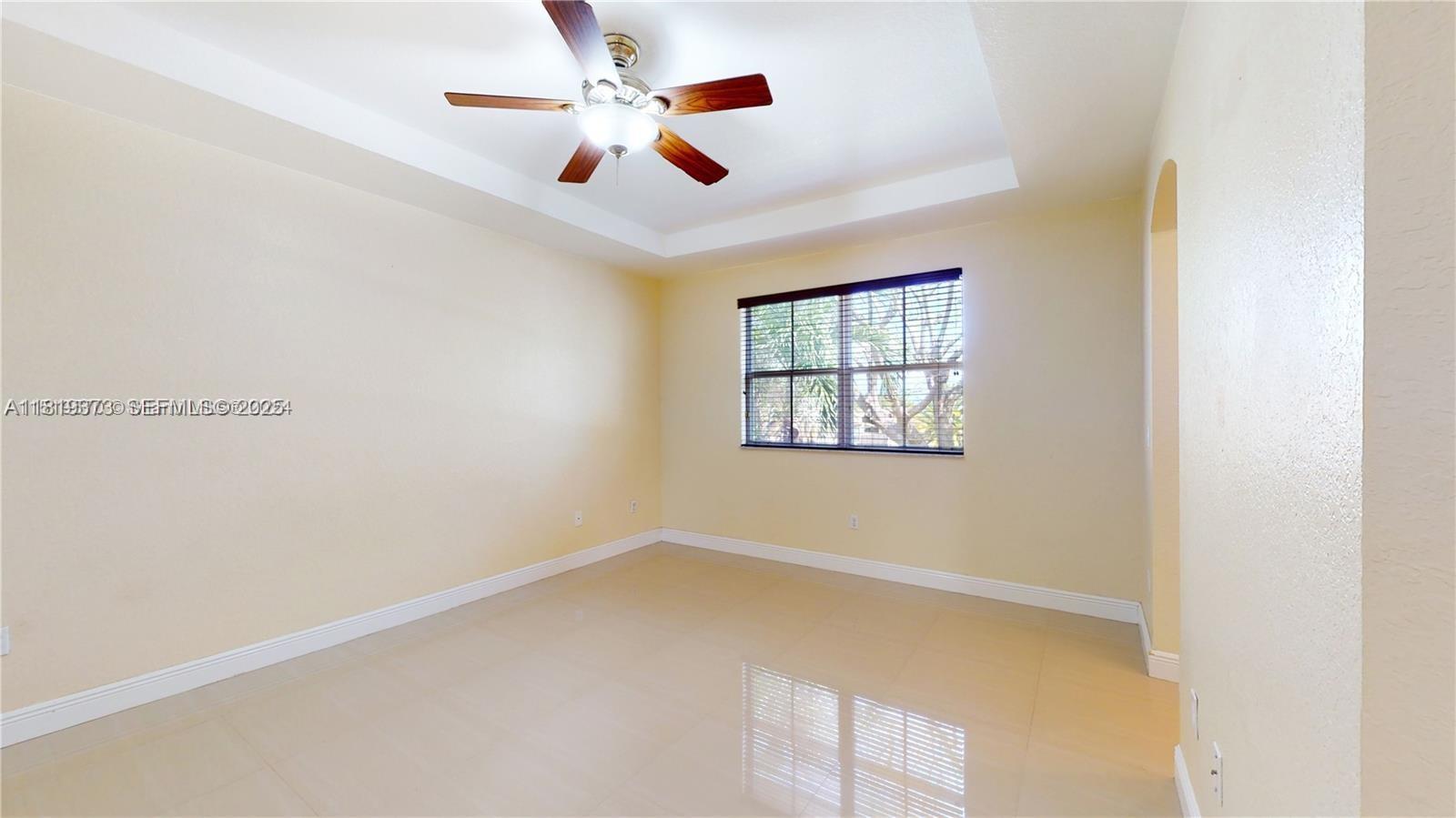 12281 Southwest 121st Terrace Miami, FL 33186 - Photo 14 of 58 an empty room with windows and ceiling fan