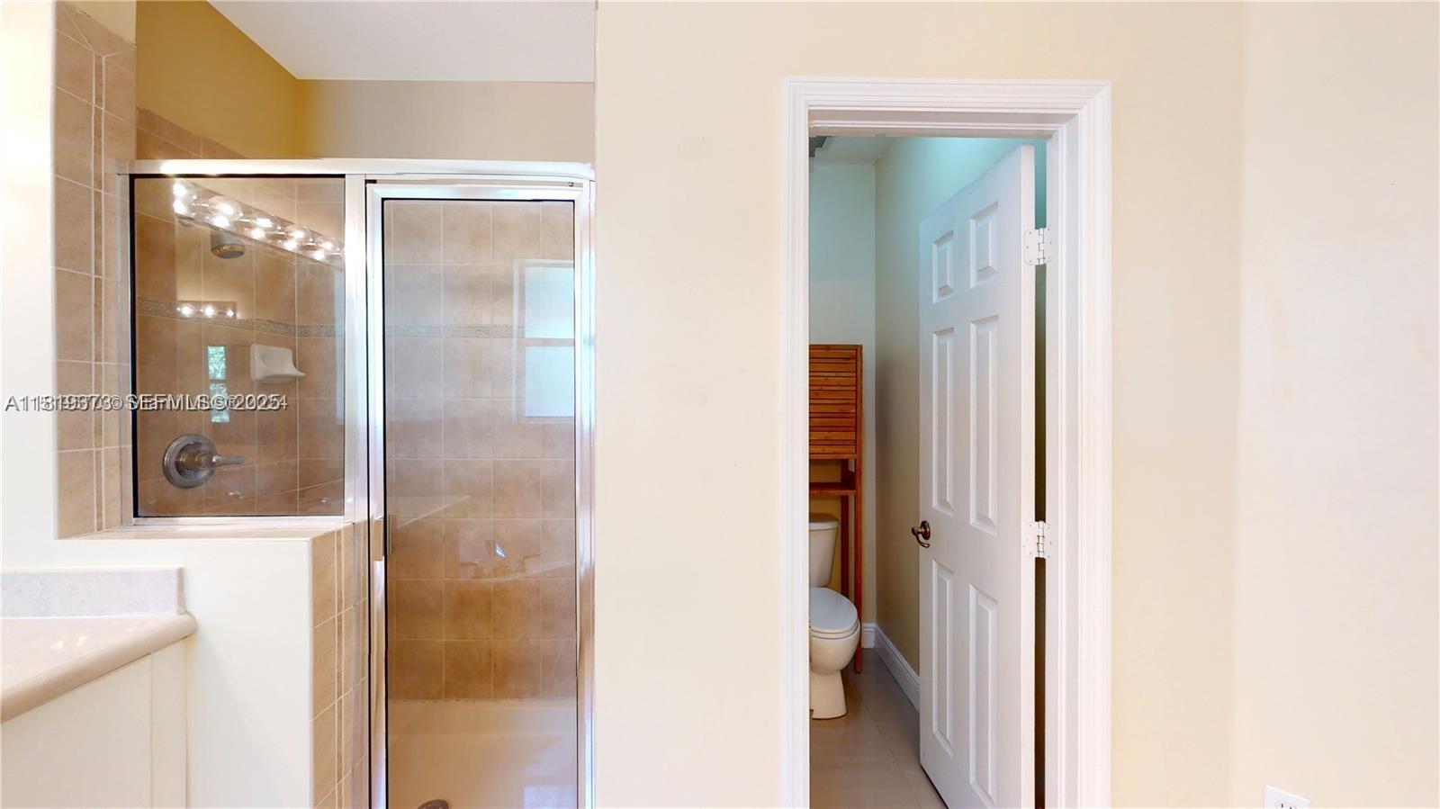 12281 Southwest 121st Terrace Miami, FL 33186 - Photo 17 of 58 a bathroom with a glass shower door and a mirror