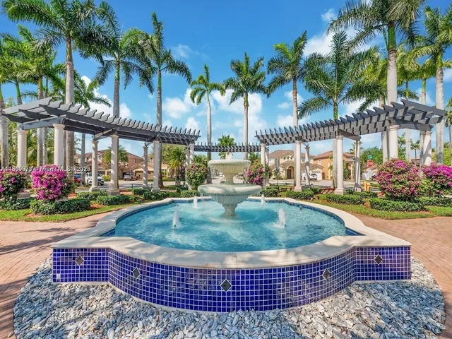 front view of multi story residential apartment building with a yard and palm trees