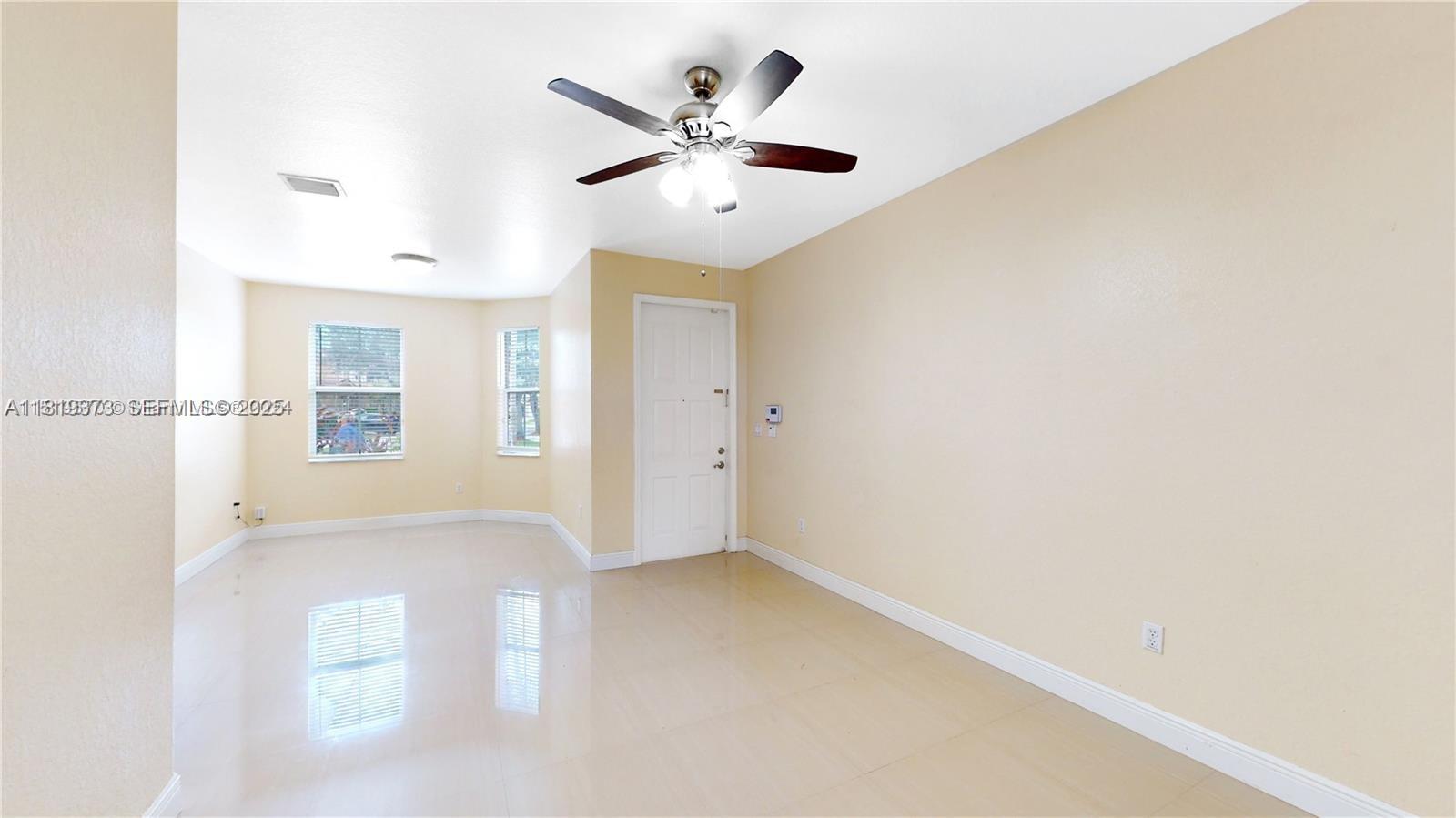 12281 Southwest 121st Terrace Miami, FL 33186 - Photo 6 of 58 an empty room with a ceiling fan and a window