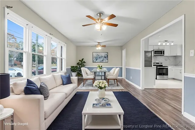 a living room with furniture and a view of kitchen