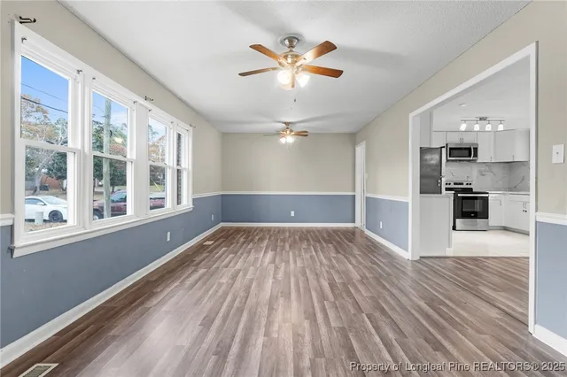 a view of empty room with wooden floor and window