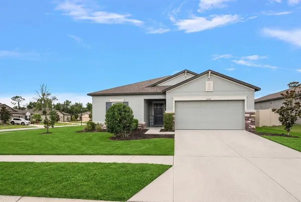 a front view of a house with a yard and garage