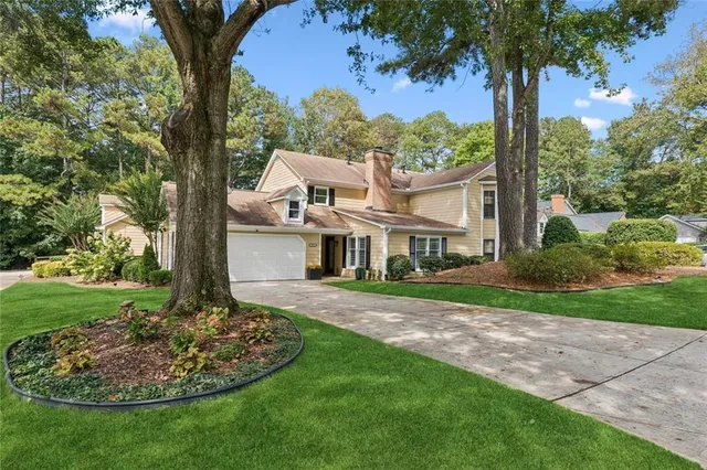 a view of a house with a yard and potted plants