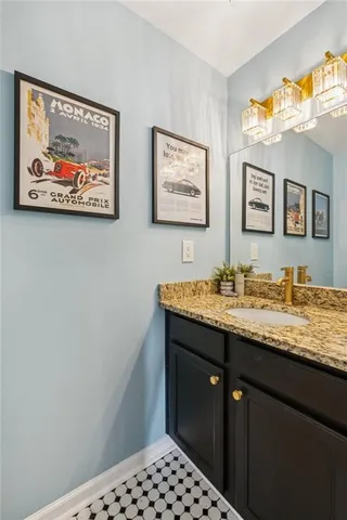 a bathroom with a sink a mirror and a picture on the wall