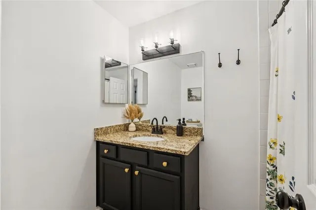 a bathroom with a granite countertop sink and a mirror