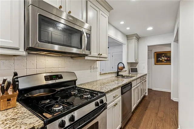 a kitchen with stainless steel appliances granite countertop a stove and a microwave