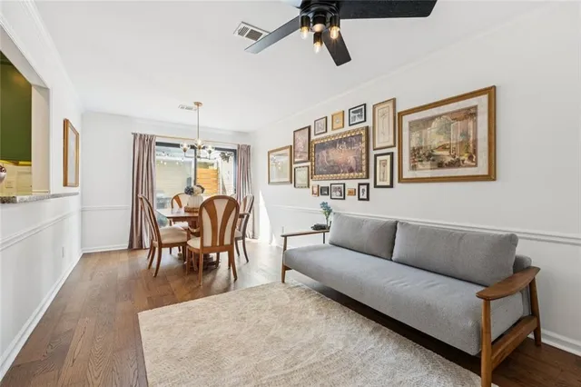 a living room with furniture kitchen view and a wooden floor