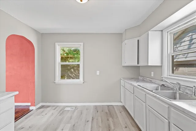 a kitchen with a sink a window and cabinets